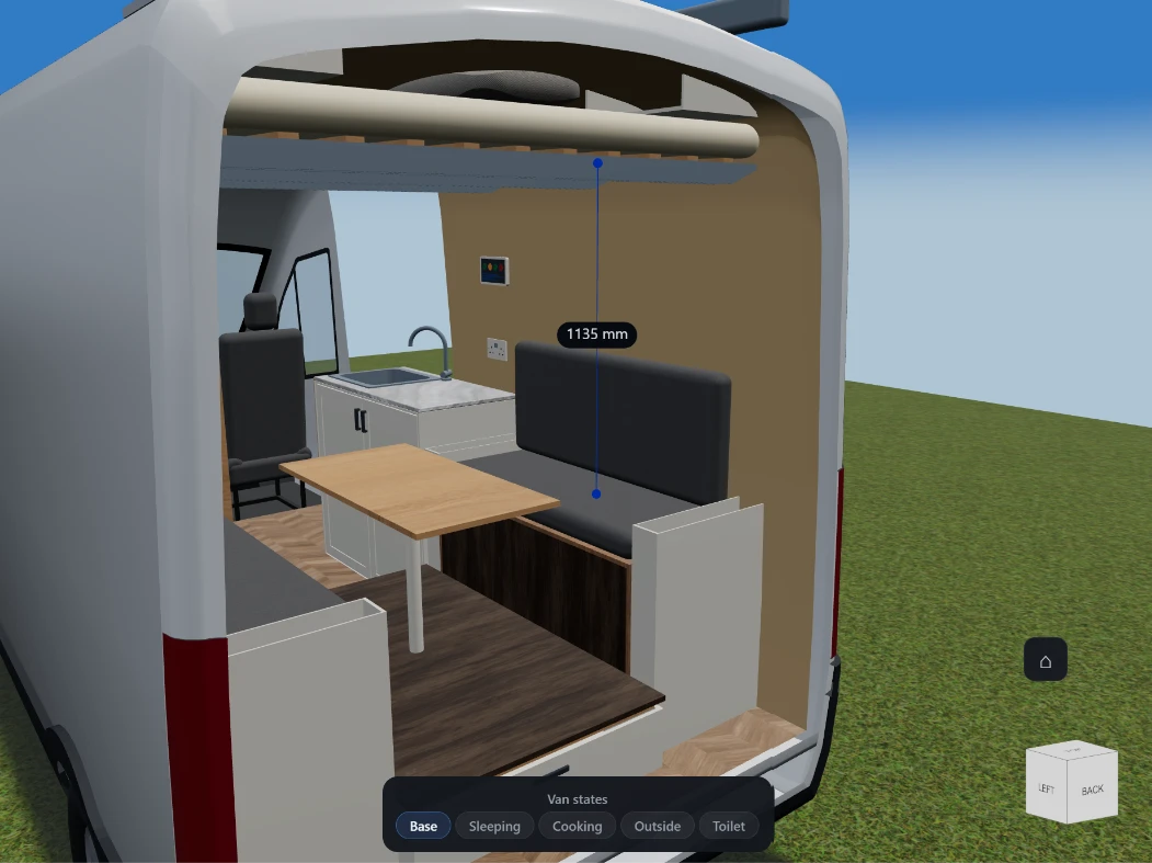 A height measurement in VanCAD’s 3D view, looking into a converted van through its open rear doors: a vertical line runs from the seat of a bench up to the slatted bed frame above it, labelled 1135 mm at its midpoint. A table, the galley and the cab seats are visible beyond, and the van-state switcher along the bottom is on Base.